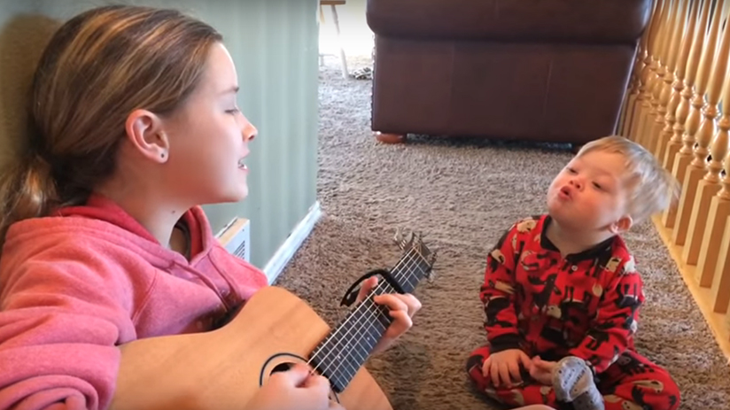 Heart-warming moment big sister teaches brother with Down syndrome to sing