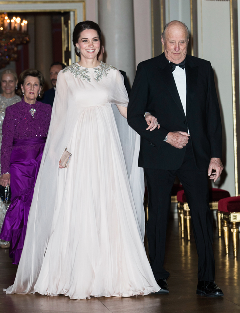 1. Looking elegant and angelic on February 1, 2018, for the official dinner at the Royal Palace in Oslo, Kate wore a blush pink ethereal gown by Alexander McQueen with a sleeveless bodice and cape overlay. The Queen's pendant diamond earrings and wedding gift bracelet added to the grandeur.