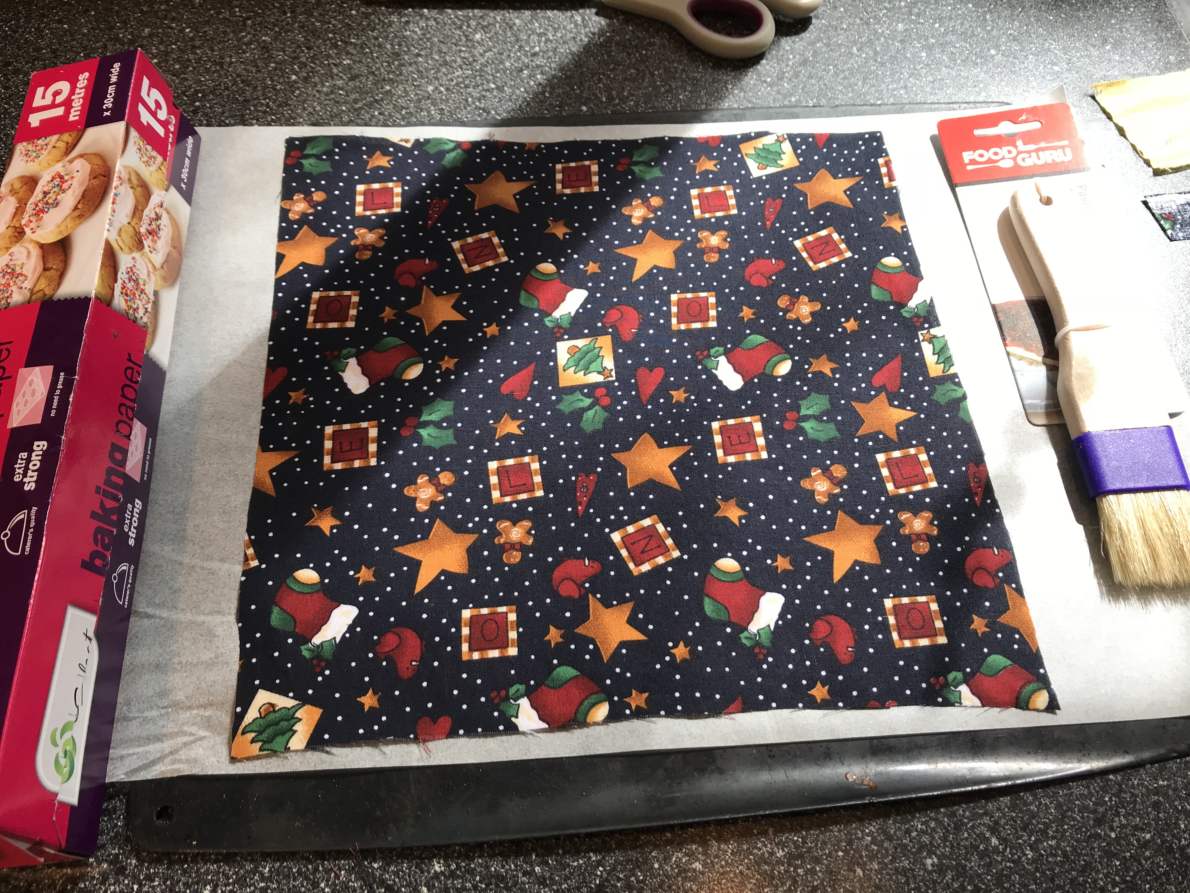 Cloth laid out on baking paper
Pastry brush at the ready to brush on wax