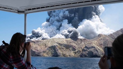 White Island erupts as a tourist boat leaves the island yesterday. Photo / Michael Schade